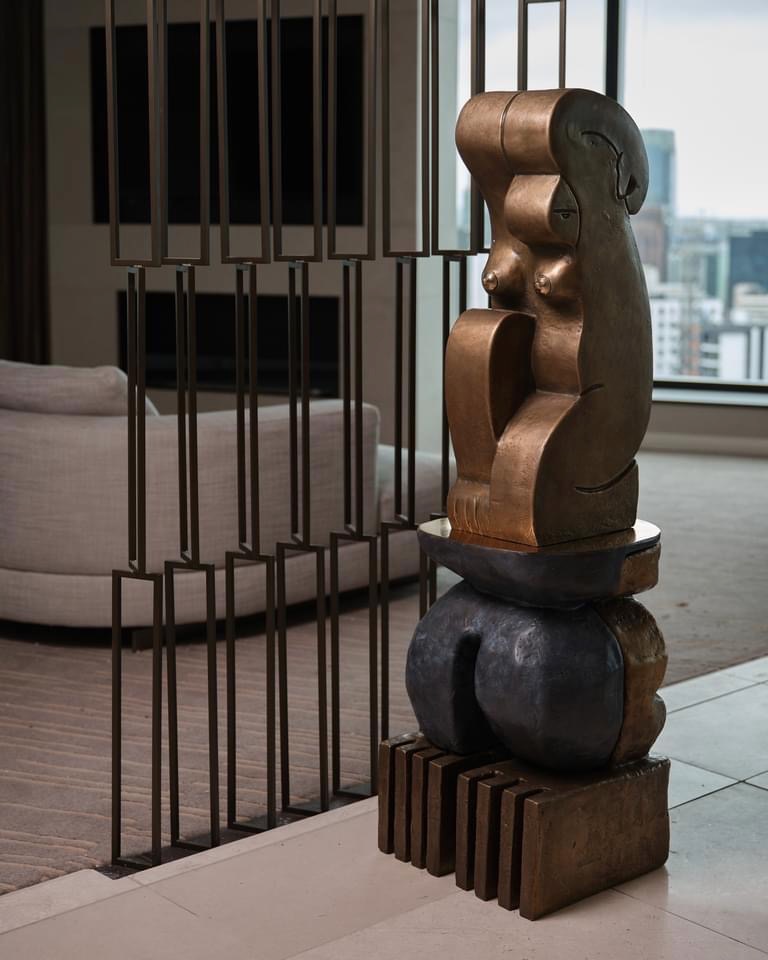 the figure in this sculpture appears
introspective, looking inward while reflecting on what has
been and preparing for what is to come. She embodies te
whai ao, or the moment before dawn, when all is still and
internal, as if she is readying herself for the spark of day.
Kneeling before the Dawn represents the hotel suite as
a space of retreat and rest, where guests might gather
themselves for the world beyond.